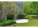 Beautifully landscaped backyard with a stone patio and lush greenery surrounding the home's exterior at 103 Woodland Ridge Ct, Cary, NC 27519