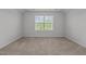 A bright bedroom features neutral carpet and a window offering natural light at 1047 Aberlour Ln, Burlington, NC 27215