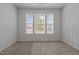 Bright bedroom featuring a large window with outside neighborhood views and neutral carpet at 1047 Aberlour Ln, Burlington, NC 27215