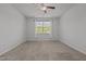Spacious bedroom featuring neutral carpet, a ceiling fan, and a large window at 1047 Aberlour Ln, Burlington, NC 27215