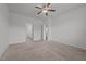Large carpeted bedroom with attached bathroom entrances and a ceiling fan at 1047 Aberlour Ln, Burlington, NC 27215