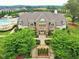 Elegant clubhouse exterior with stone accents, lush landscaping, and a view of the community pool at 1047 Aberlour Ln, Burlington, NC 27215