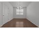 Bright living room features hardwood floors, a window with blinds, and a modern chandelier at 1047 Aberlour Ln, Burlington, NC 27215