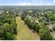 Aerial view showcases homes near a golf course, surrounded by lush greenery and trees at 107 Weslyn Trace Dr, Durham, NC 27703