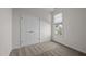 Bedroom with neutral carpet, white walls, double door closet and window at 107 Weslyn Trace Dr, Durham, NC 27703