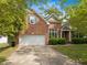 Charming brick home featuring an attached two-car garage and lush landscaping at 107 Weslyn Trace Dr, Durham, NC 27703