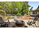Backyard featuring a stone fire pit, seating, a gravel area, and lush trees, perfect for outdoor gatherings at 107 Whitby Ct, Cary, NC 27511