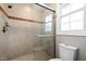 Bathroom featuring glass shower, tiled walls and floors, toilet, and window at 107 Whitby Ct, Cary, NC 27511
