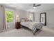 Bedroom with ceiling fan, two windows, mirror, and neutral decor at 107 Whitby Ct, Cary, NC 27511