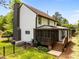 Exterior view of the home featuring a screened porch, a fenced yard, and lush greenery, offering outdoor living at 107 Whitby Ct, Cary, NC 27511