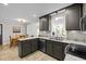 Stylish kitchen with dark cabinetry, granite countertops, and a view into the breakfast nook and living area at 107 Whitby Ct, Cary, NC 27511