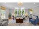 Bright and airy living room featuring hardwood floors, large windows, and stylish furnishings at 107 Whitby Ct, Cary, NC 27511