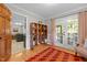 Comfortable room with wood floors, large french doors leading to porch, and decorative shelving at 107 Whitby Ct, Cary, NC 27511
