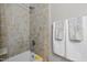 Shower with tan tiled walls and a shower head, complemented by white towels for a clean and functional space at 107 Whitby Ct, Cary, NC 27511