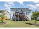 A home's backyard showing a wooden staircase to the back deck and ample green space at 108 Sunburst Dr, Durham, NC 27705