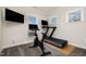Well-lit exercise room with a treadmill, exercise bike, and mounted TV at 108 Sunburst Dr, Durham, NC 27705