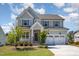 Charming two-story home with a well-manicured lawn, stone accents, attached garage and inviting front porch at 108 Sunburst Dr, Durham, NC 27705