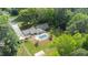 Aerial view of property with in-ground pool, patio, manicured lawn, and surrounded by mature trees at 11 Pine Forest Dr, Siler City, NC 27344