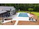 Aerial view of backyard with in-ground pool, outdoor seating, covered patio, and surrounding trees at 11 Pine Forest Dr, Siler City, NC 27344