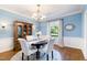 Inviting dining room with blue walls, white wainscoting, and a round table beneath an elegant chandelier at 11 Pine Forest Dr, Siler City, NC 27344