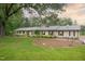 Charming brick home features a well-maintained lawn, mature trees, and a welcoming facade with dark green shutters at 11 Pine Forest Dr, Siler City, NC 27344