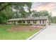 Charming brick home features a well-maintained lawn, mature trees, and a welcoming facade with dark green shutters at 11 Pine Forest Dr, Siler City, NC 27344