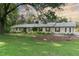 Charming brick home features a well-maintained lawn, mature trees, and a welcoming facade with dark green shutters at 11 Pine Forest Dr, Siler City, NC 27344