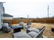 Back patio with a seating area, black fire pit, and a wooden fence in the background at 1108 Orchard Stream Dr, Haw River, NC 27258