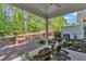 Covered patio with chairs and view of lush backyard in a wooded setting at 1230 Wingstem Pl, Raleigh, NC 27607