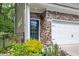 Inviting entryway with stone accents, a blue front door with glass, and lush landscaping at 1230 Wingstem Pl, Raleigh, NC 27607