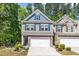 Charming two-story townhome featuring a two-car garage, stone accents, and manicured landscaping at 1230 Wingstem Pl, Raleigh, NC 27607