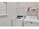 Functional laundry room features a modern washer and dryer, along with shelving for storing laundry supplies at 1230 Wingstem Pl, Raleigh, NC 27607