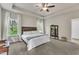 This main bedroom features tray ceilings, a ceiling fan, and a wooden headboard, and two windows allowing for plenty of natural light at 1230 Wingstem Pl, Raleigh, NC 27607