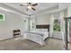 Bright main bedroom boasts a tray ceiling, ceiling fan, and a wooden headboard, with plenty of light streaming in from two windows at 1230 Wingstem Pl, Raleigh, NC 27607