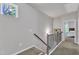 Carpeted staircase with wooden handrail and iron spindles lead up to the second floor, with a window providing natural light at 1230 Wingstem Pl, Raleigh, NC 27607