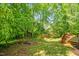 Enjoy a spacious backyard with lush greenery and a small wooden deck, perfect for relaxation at 1305 Montreux Ct, Mebane, NC 27302