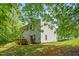 View of home's backyard with mature trees, a deck, and lush greenery at 1305 Montreux Ct, Mebane, NC 27302