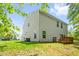 Back exterior featuring a wooden deck, green lawn, siding and windows with green trees at 1305 Montreux Ct, Mebane, NC 27302