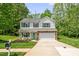 Charming two-story home features a well-manicured lawn, attached two-car garage, and inviting front porch at 1305 Montreux Ct, Mebane, NC 27302