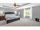 Bright main bedroom with a ceiling fan, tray ceiling, carpet, and a large window for natural light at 1305 Montreux Ct, Mebane, NC 27302