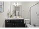 Bathroom with dark vanity, oval mirror, and tiled walk-in shower at 140 Barletta Ct, Clayton, NC 27527