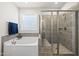 Bathroom with tiled walk-in shower, large tub and window at 140 Barletta Ct, Clayton, NC 27527