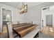 Bright dining room with wooden table, bench, comfortable chairs, and modern light fixture at 140 Barletta Ct, Clayton, NC 27527