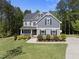 Charming two-story home boasts gray siding, black shutters, lush landscaping, and a welcoming front porch at 140 Barletta Ct, Clayton, NC 27527