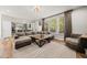 Open-concept living room featuring a plush sectional sofa, large windows, and modern decor at 140 Barletta Ct, Clayton, NC 27527