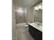 Full bathroom featuring a shower-tub combo, grey tile surround and dark wood vanity with ample storage at 1403 Cottondale Lane, Wake Forest, NC 27587