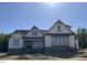 New construction home featuring stone accents, white siding, and a charming architectural design with excellent curb appeal at 1403 Cottondale Lane, Wake Forest, NC 27587