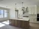 Gourmet kitchen with a large central island, pendant lighting, and modern appliances, designed for culinary enthusiasts at 1403 Cottondale Lane, Wake Forest, NC 27587