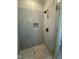 Bathroom shower featuring gray vertically stacked tile, mosaic floor, glass door, and bronze shower fixtures at 1403 Cottondale Lane, Wake Forest, NC 27587