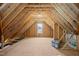 Unfinished attic with wooden beams and plywood offering potential for customization and additional storage space at 145 Leisure Ln # 12, Louisburg, NC 27549